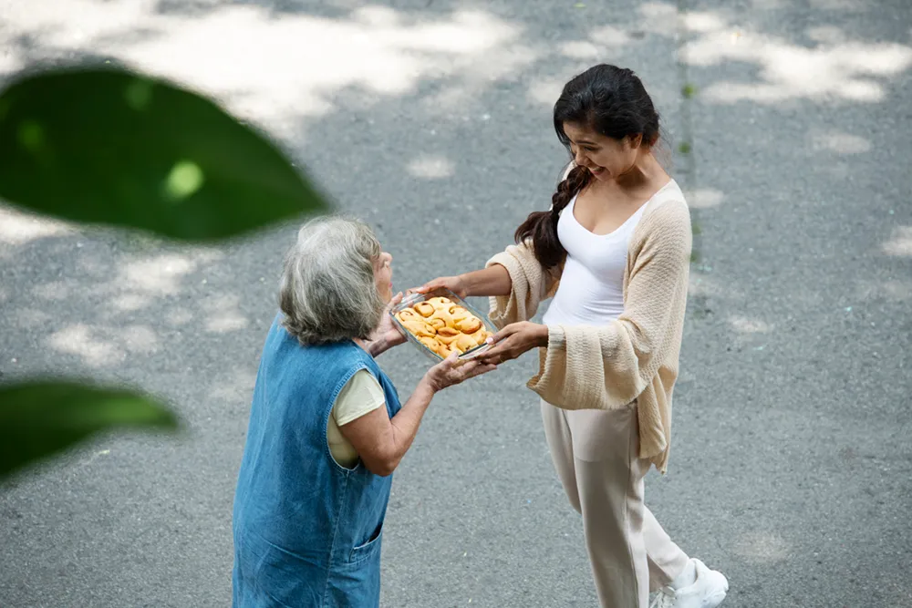 Woman offering food to neighbor